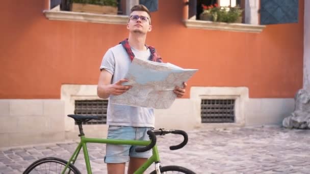 Boy utiliza el mapa en la ciudad — Vídeo de stock