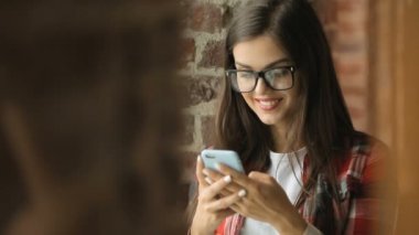 Genç kadın gülümsüyor bir telefon mesajı okuma olarak oldukça klasik bir şekilde döşenmiş rahat yazlık rahatlatıcı olarak Gadget'ı kullanma