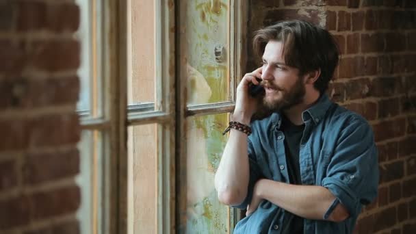 Hombre habla por teléfono por ventana — Vídeos de Stock