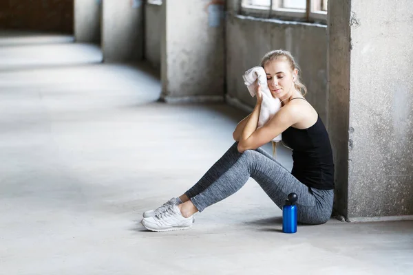 Trött ung kvinna med handduk vila efter träning — Stockfoto