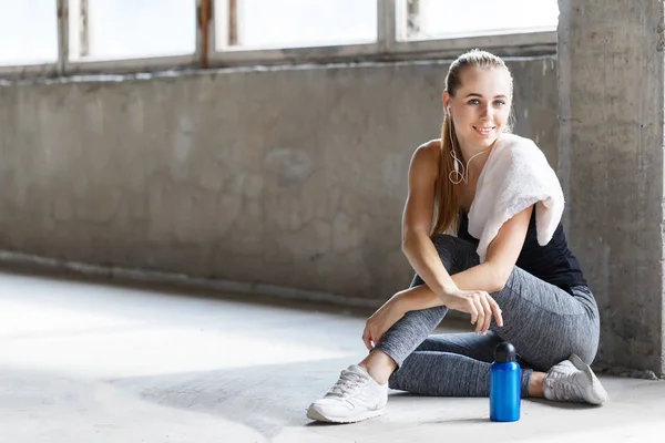 Sport tjej sitter och ler i gymmet — Stockfoto