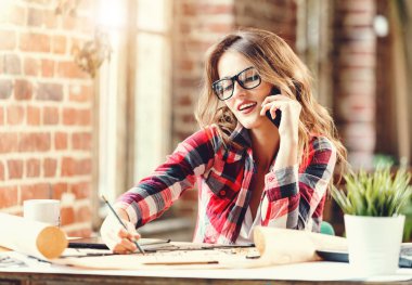 Cep telefonu kullaranarak kadın uzun saçlı mimar