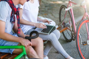 Beanch üzerinde oturan dizüstü bilgisayar ile çift