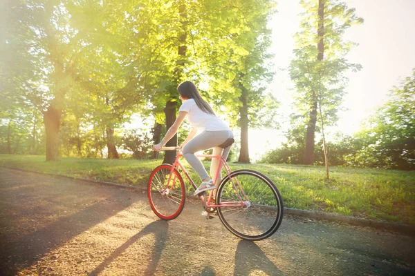 Mädchen fährt Fahrrad bei Sonnenuntergang — Stockfoto
