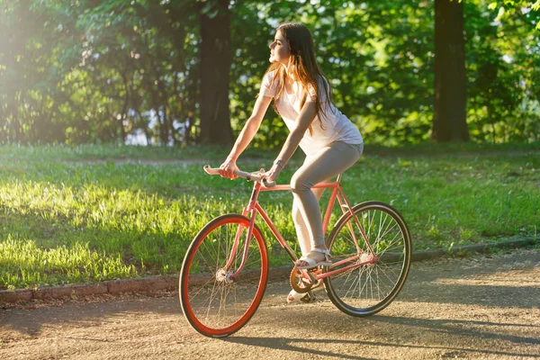 Hübsche Mädchen fahren auf rosa Fahrrad — Stockfoto