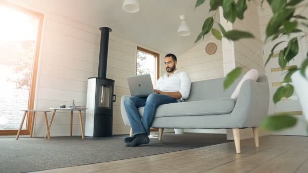 Hombre utiliza el ordenador portátil — Vídeos de Stock