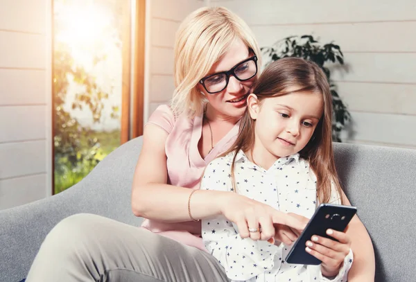 Madre e hija usando teléfono móvil — Foto de Stock