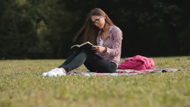Читає дівчина в парку — стокове відео