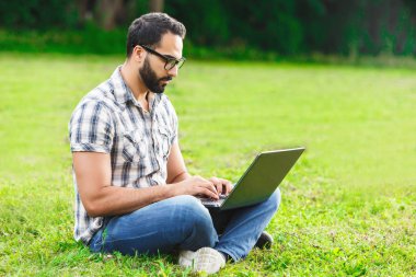 genç adam dizüstü bilgisayarda yazarak