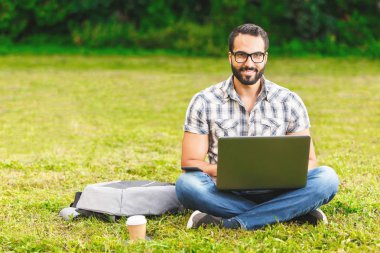 Sakallı adam dizüstü bilgisayarda yazarak