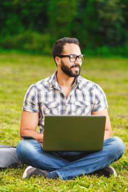 Dizüstü bilgisayarda çalışma bardaklarda sakallı adam