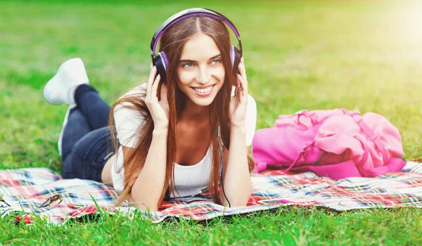 Genç kadın müzik yaz parkta dinlemek — Stok fotoğraf