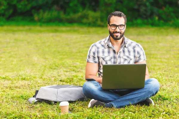 Sakallı adam dizüstü bilgisayarda yazarak