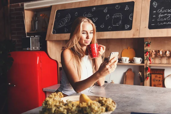 Linda chica bebiendo café y revisando su correo electrónico — Foto de Stock