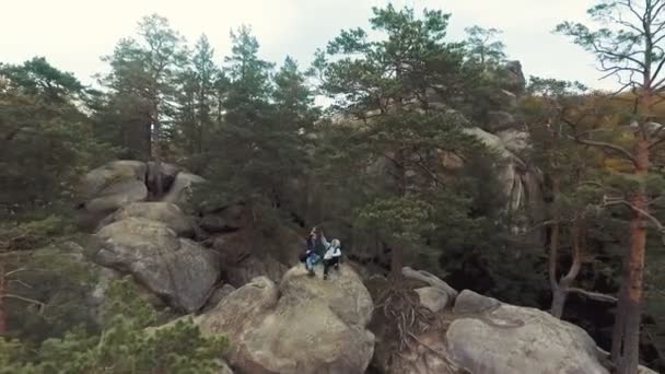 满意的朋友给予高五坐在大石头上 合作的概念在任何类型的活动 户外射击在早期秋天 — 图库视频影像