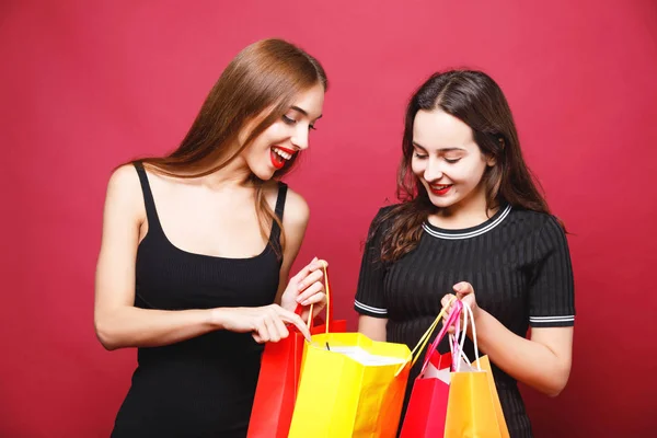 Zwei süße Freundinnen mit vielen Einkaufstüten — Stockfoto
