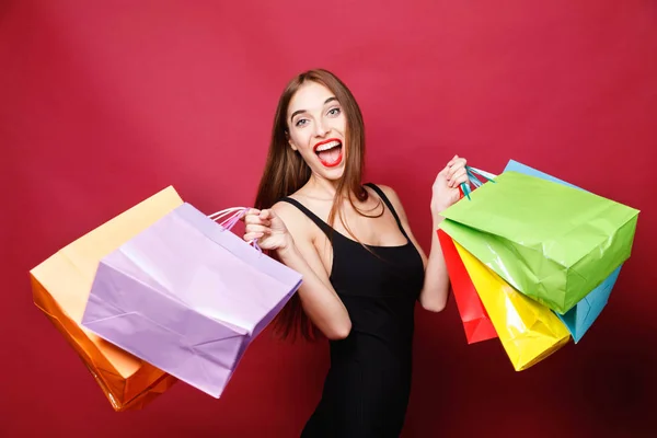 Attraktive Frau springt mit vielen Einkaufstüten — Stockfoto