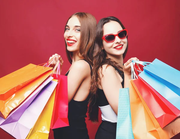 Zwei Freundinnen mit vielen bunten Papiereinkaufstaschen — Stockfoto