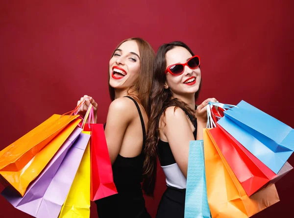 Two Girlfriends Holding Many Colorful Paper Shopping Bags