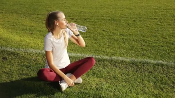 Chica bebe agua como descanso — Vídeo de stock