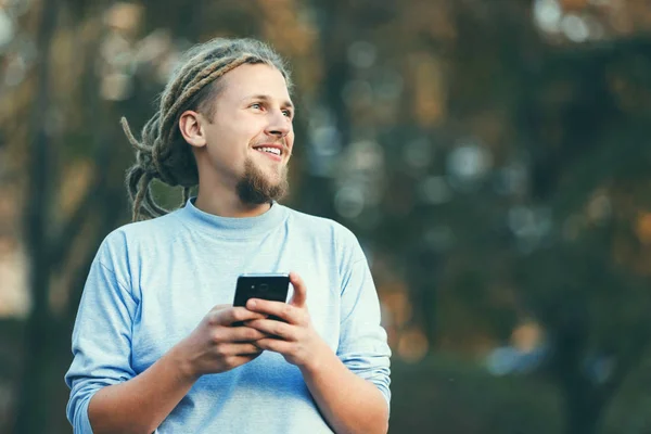 Блондинка Бородатий чоловік ходить вулицею і обманює смартфон — стокове фото