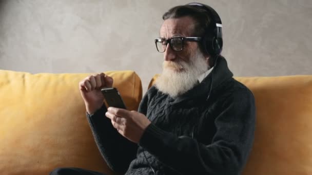 Старший громадянин слухає музику — стокове відео