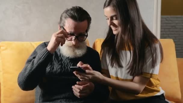 Nieta enseña al abuelo a usar el teléfono — Vídeo de stock