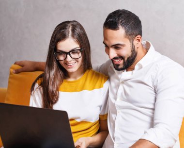 Genç çift dizüstü bilgisayar kullanıyor