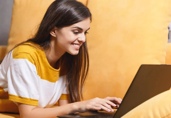Fröhliches Mädchen liegt mit ihrem Laptop — Stockfoto