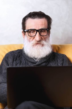 Dizüstü bilgisayar kullanan kıdemli adam.