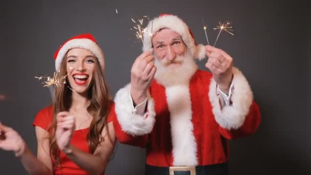 Дед Мороз и Снегурочка танцуют с фейерверками — стоковое видео