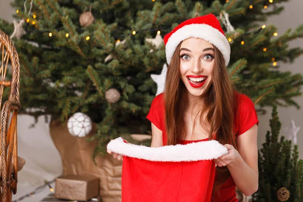 Leuke kerst vrouw dragen KERSTMUTS geschokt door de geschenken — Stockfoto