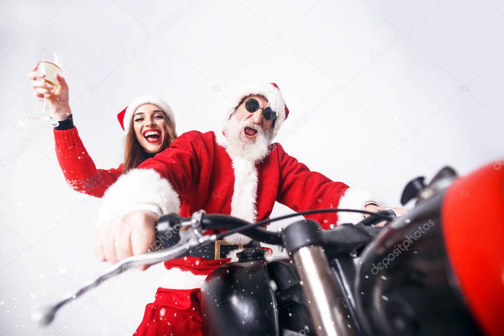 Santa Claus And Young Mrs. Claus Riding A The Motorcycle