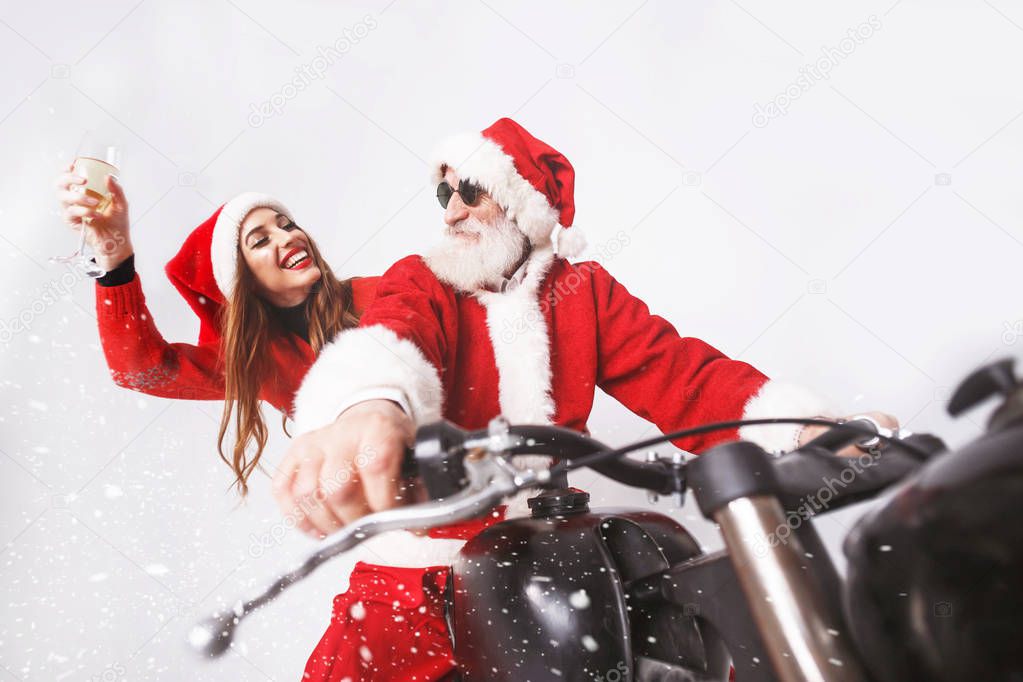 Santa Claus And Young Mrs. Claus Riding A The Motorcycle