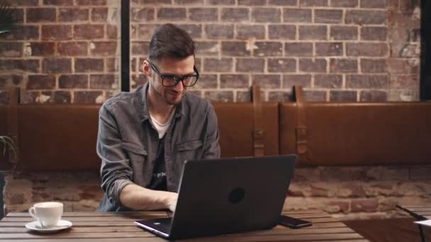 Програміст друку на ноутбуці в кафе — стокове відео