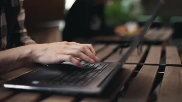 Na volné noze muž psaní na notebooku — Stock video