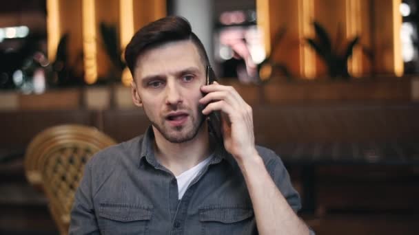 Hombre escuchando noticias impactantes en el teléfono inteligente — Vídeo de stock