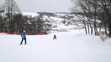 Tepeden aşağı Kayak antrenörü ve çocuk