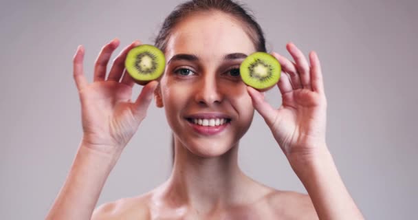 Girl Hiding Her Eyes with Kiwi Slices — Stock Video