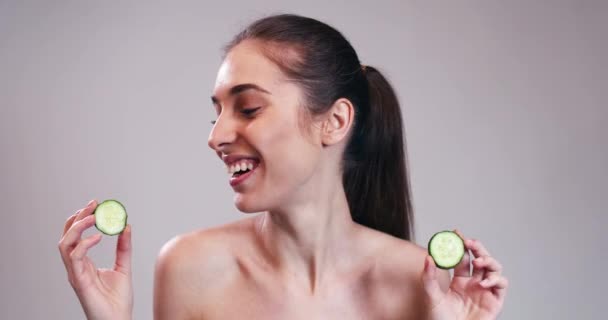 Meisje verbergen ogen achter plakjes komkommer — Stockvideo