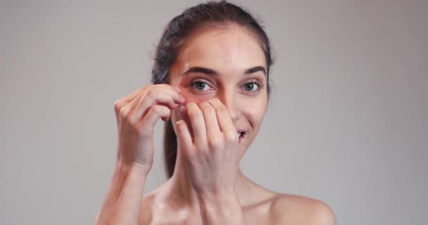 Mujer poniendo almohadillas de colágeno bajo sus ojos — Vídeos de Stock