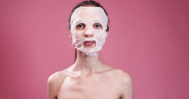 Jonge vrouw verwijdert gezichtsmasker — Stockvideo
