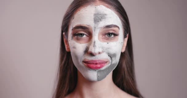 Jeune fille souriante avec masque en argile sur le visage — Video