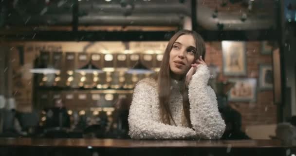Девушка разговаривает по телефону в кафе — стоковое видео