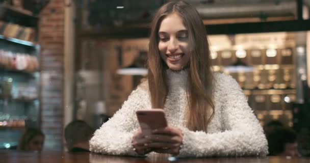 Усміхнена дівчина зайнята за допомогою смартфона — стокове відео