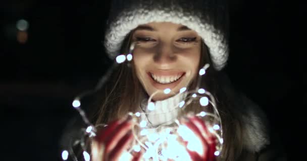 Menina feliz segurando pequenas luzes de decoração — Vídeo de Stock