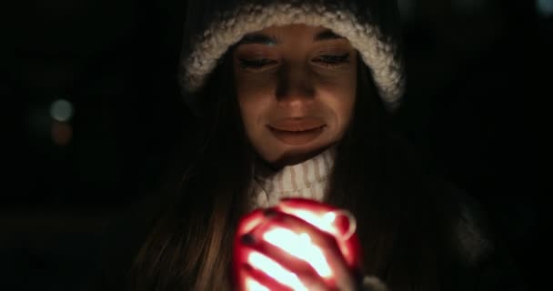 Meisje ontvouwen handen gevuld met kleine decoratie lichten — Stockvideo