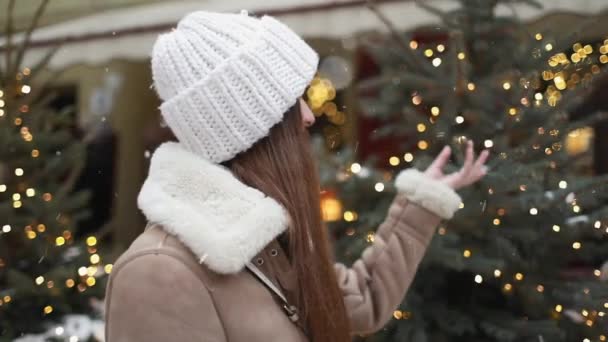 Chica tocando el árbol de Navidad en la calle — Vídeo de stock