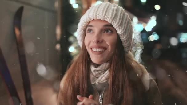 Mooi meisje genieten van sneeuwval in de stad — Stockvideo