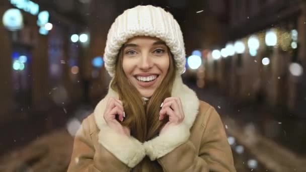 Πορτρέτο του χαμογελαστή κορίτσι τη νύχτα κατά τη διάρκεια χιονοπτώσεις — Αρχείο Βίντεο